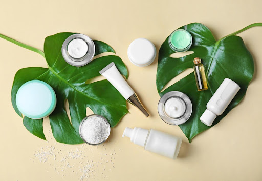 An assortment of skin care products on top of two green leaves.